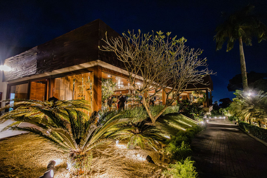Fachada da Casa do Alto destaca os amplos painéis de vidro, os elementos em madeira e a integração dos ambientes internos com os jardins | Foto: Divulgação/Casa do Alto