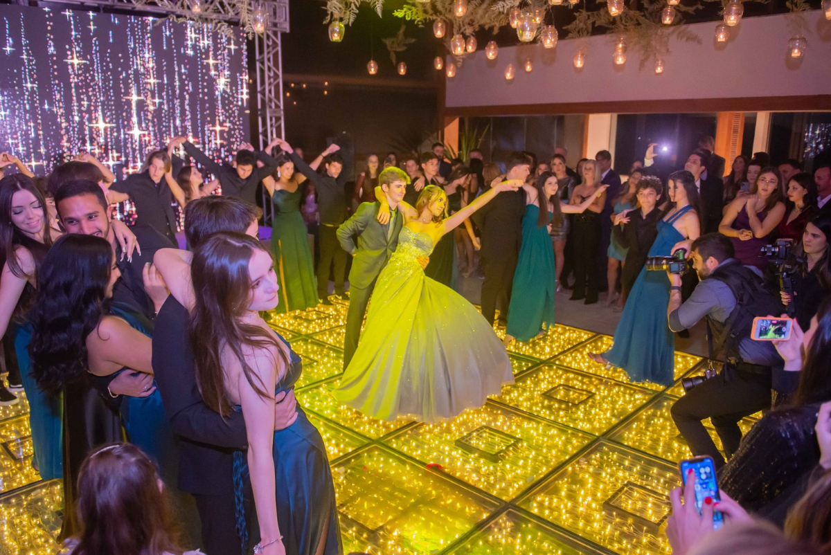A pista de dança iluminada reúne a debutante e seus convidados, com efeitos de luz e painéis de LED que integram a produção da festa | Foto: Bruno Felipe Fotografia